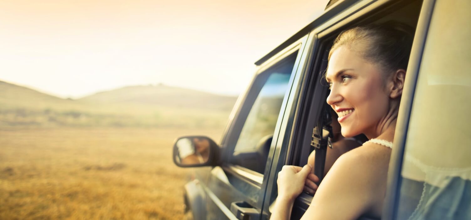 Woman enjoying the sunny weather in a vehicle